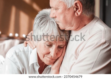 Close up mature man comforting frustrated crying woman, hugging shoulders, caring elderly husband and wife overcoming troubles, health problems, consoling and supporting, psychological help
