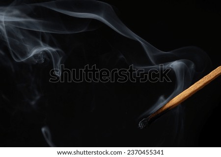 Smoke from a match that was just put out, isolated on black background.