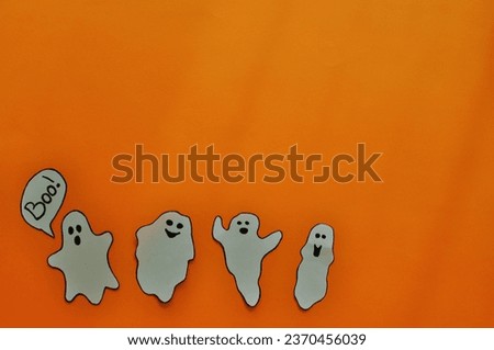 funny halloween background - ghosts on the orange background 