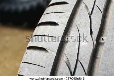 Tire tread wear indicator, Close up of tire with tire tread wear indicator showing on tread grooves, Automotive parts concept Royalty-Free Stock Photo #2370456849