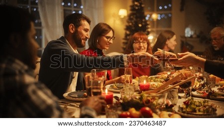 Portrait with Parents, Children and Friends Enjoying Christmas Dinner Together in a Cozy Home in the Evening. Relatives Sharing Meals, Singing Traditional Festive Songs and Setting Off Fireworks