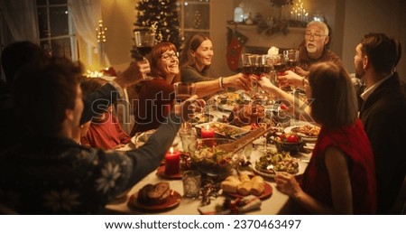 Parents, Children and Friends Spend Christmas Dinner Together at Home. Multicultural Family Raising Wine Glasses and Toasting, Celebrating a Holiday with a Delicious Turkey Meal Royalty-Free Stock Photo #2370463497