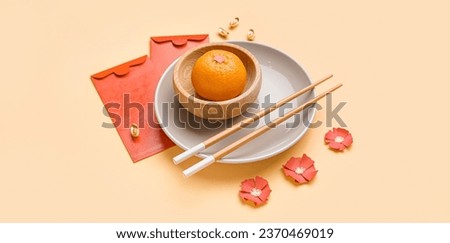 Table setting with red envelopes, tangerine and Chinese symbols on light color background
