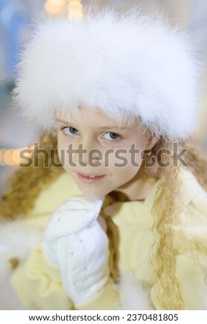 a little girl dressed in a red dress sitting in a room with Christmas decoration