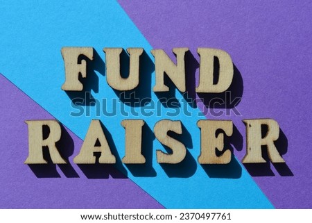 Fund Raiser, words in wooden alphabet letters isolated on background as banner headline