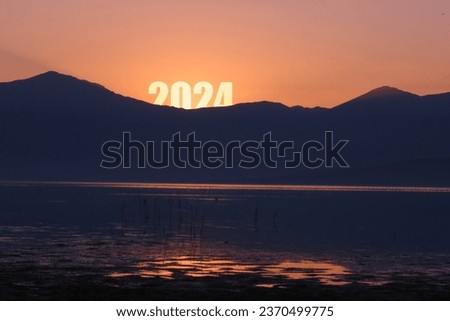 
Happy New Year 2024 anniversary. Transition from 2023 to new year 2024 concept with text on sun rising sky. Photo image can be used as large display, print, website banner, social media post.