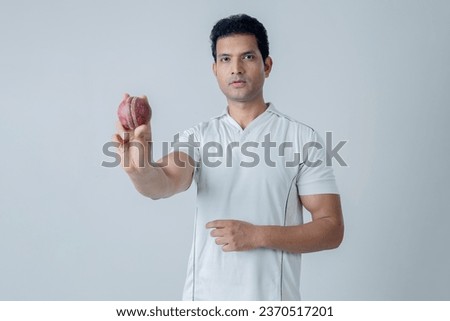 Portrait of cricketer holding boll and showing seem position of boll towards the camera, Cricket concept shoot