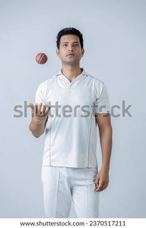 Portrait of Cricketer holding cricket boll in hand and looking towards the camera in aggression , Cricket concept shoot