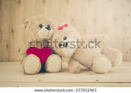 two teddy Bear with Heart on wood background,vintage tone,concept valentine