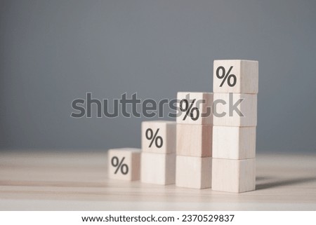 Rising financial interest rate graph concept. Wooden blocks with increasing percentage icons, financial business, investing or home mortgages, inflation.