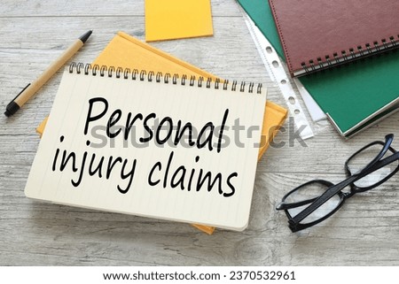 Text Personal injury claims. work table notepad on yellow notepad. text