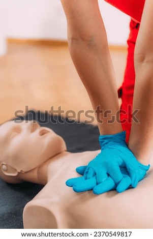 CPR Training Course. Chest compression techniques in a CPR first aid training with a dummy. Royalty-Free Stock Photo #2370549817
