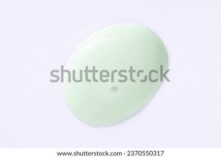 Cosmetic light green cream blob swatch on white background. Pastel green face cream, makeup primer, color correcting cosmetic product, serum