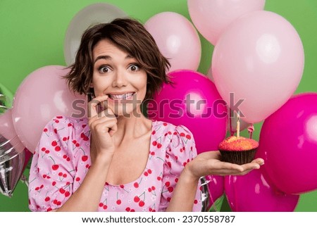 Photo of funky tricky lady wear pink blouse finger chin holding cupcake celebrating birthday isolated green color background