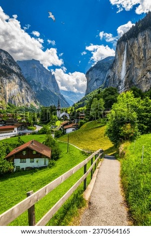 Lauterbrunnen valley with famous church and Staubbach waterfall. Lauterbrunnen village, Berner Oberland, Switzerland, Europe. Spectacular view of Lauterbrunnen valley in a sunny day, Switzerland. Royalty-Free Stock Photo #2370564165