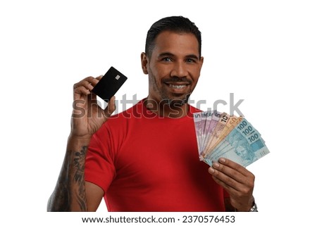  Man with a black credit card and Brazilian money in his hand, red clothes, on white background