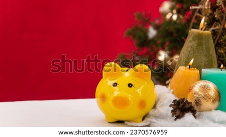 piggy bank decorated in Christmas celebration theme on white table reb background with copy-space, family spent time together in winter Christmas holiday 