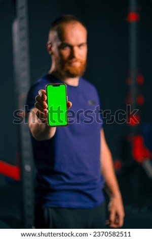 man fitness trainer show phone with green screen sport lifestyle training technology