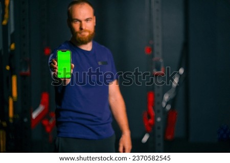 man fitness trainer show phone with green screen sport lifestyle training technology