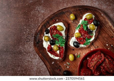 sandwich with cream cheese, dried tomatoes, olives, breakfast, top view, Royalty-Free Stock Photo #2370594561