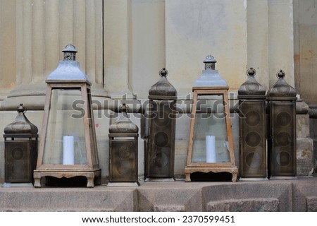 Set of seven vintage candle lanterns featuring two different designs and two sizes each, one completely metal and the other in glass, wood and tin, all with a candle inside. Melbourne-VIC-Australia. Royalty-Free Stock Photo #2370599451