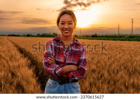 The Chinese farmer woman strikes a pose for a photo in the wheat field, radiating confidence and pride in her agricultural endeavors.