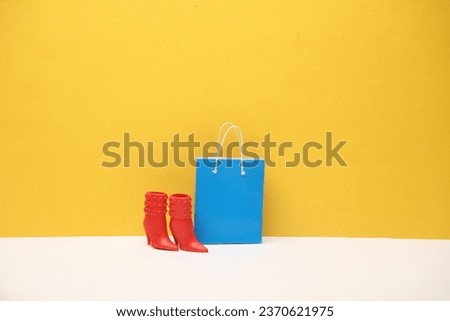 Shopping bags with doll boots on yellow background. Shopping, sale concept
