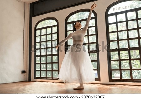 Asian girl ballet dancer creative performance with white skirt demonstrating dancing skill Young graceful  ballerina training exercise body practice on studio wellness Beauty classic ballet.