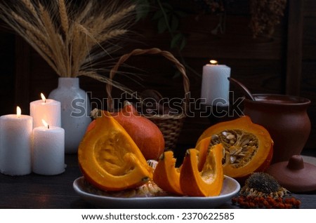 autumn pumpkin sliced on a wooden table. Romantic candlelit dinner, dry spikelets Village Concept