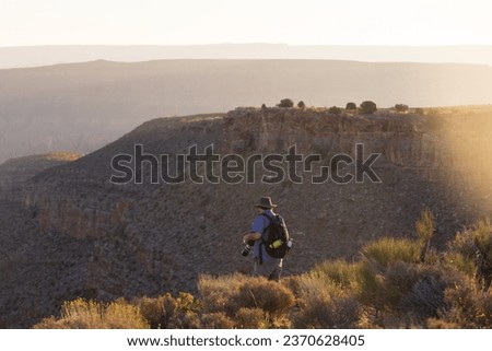 hiker standing on a cliff of a mountain