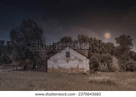 Gloomy Halloween landscape with an abandoned creepy house and the moon.