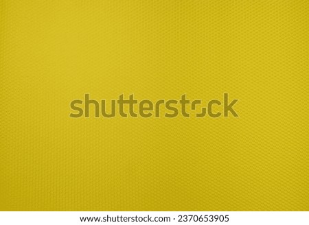 A yellow background texture made up of small hexagons that are slightly convex. The hexagons are arranged in a repeating pattern