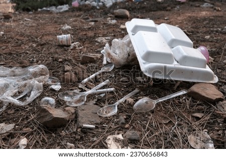 Single-use plastic cutlery left to nature. Polycarbonate trays used in takeaways.  Royalty-Free Stock Photo #2370656843