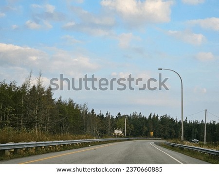 An open highway with a sharp corner extending along it.