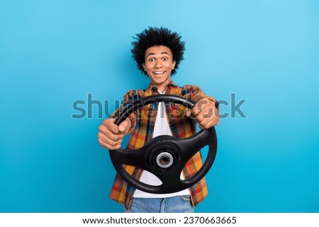 Portrait of impressed guy with perming coiffure dressed plaid shirt test new car hold steering wheel isolated on blue color background Royalty-Free Stock Photo #2370663665