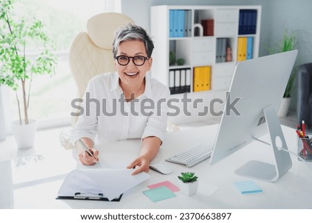 Photo of satisfied businesswoman signature her first big contract deal proposition finally success isolated on modern office background