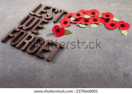 World War remembrance day. Red poppies on dark stone background. Lest we forget