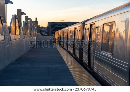 Sunrise on the train platform as the G Train arrives at the Smith Street station over the Gowanus Canal in Brooklyn, New York. 