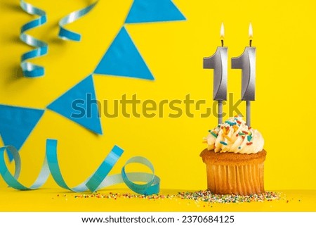 Birthday candle number 11 with cupcake - Yellow background with blue pennants