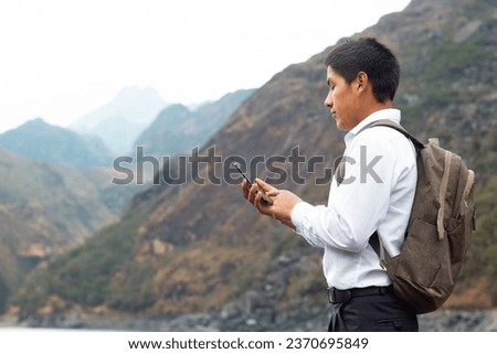 Young peasant student on a lake while using a smartphone looking at an advertising space and isolated on a nature background, contact, cell phone, communication, lifestyle Royalty-Free Stock Photo #2370695849
