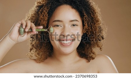 Happy woman, portrait or jade roller in studio with anti aging product or facial tool on brown background. Smile, beauty or proud biracial girl model with cosmetics for wellness or natural skincare
