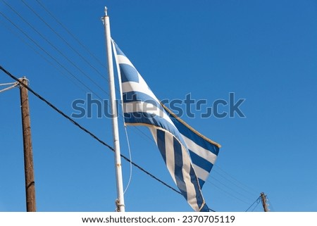Waving Greek flag with brilliant blue skies in the background.