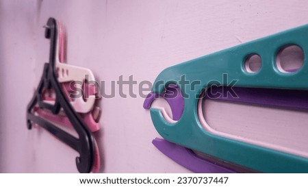 a clothes hanger hanging on a nail on a purple wall. selective focus