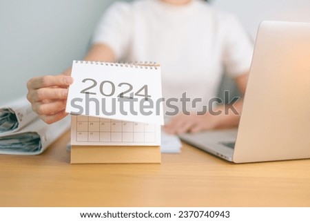 2024 Year Calendar on table with business woman using laptop computer. countdown, Happy New Year, Resolution, Goals, Plan,  Action, Mission and financial Concept Royalty-Free Stock Photo #2370740943