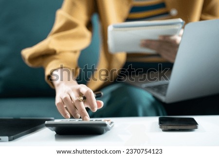 woman working on laptop and accounting financial report, accountant using calculator to calculate tax refund at office. Royalty-Free Stock Photo #2370754123