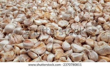 Pile of white garlic head on supermarket table for cooking ingredient.