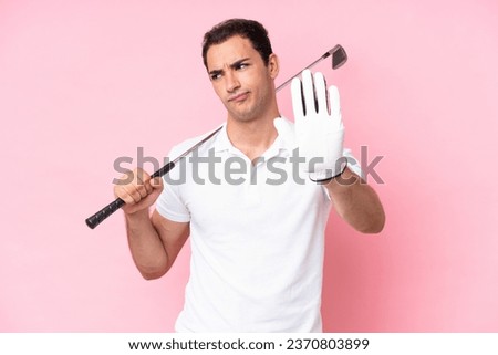 Young golfer player man isolated on pink background making stop gesture and disappointed