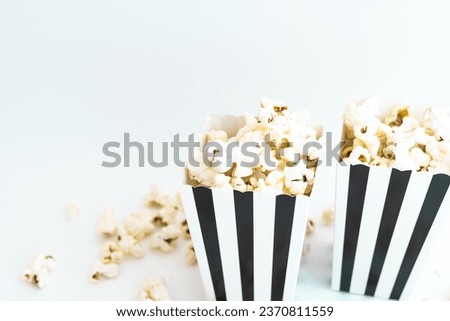 Black and white striped boxes with popcorn. Entertainment concept. Movie night with popcorn. 