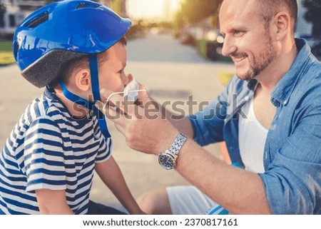 Father putting protective face mask on his child.