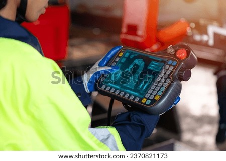 Smart engineer staff worker use digital remote control operate industry robot arm in automation factory technology engineering Royalty-Free Stock Photo #2370821173